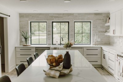Cultured Stone Country Ledgestone Wheaton thin stone as backsplash in white kitchen with black trimmed windows