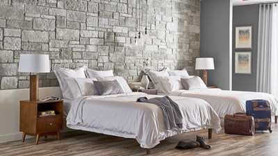 Cultured Stone Sculpted Ashlar Silver Shore gray thin stone on interior wall of hotel room with two beds 